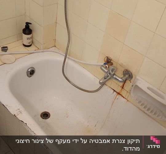 אמבטיה עם ברז חלוד וצינור מים